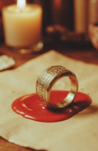 Old signet ring on table with candle. 